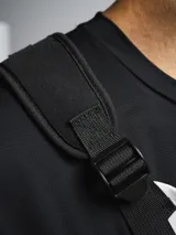 Bolso de pecho táctico color gris claro con detalles en negro. Posee un compartimento principal con cierre y correas ajustables negras para llevar cruzado sobre el pecho.