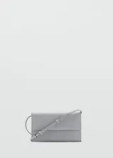 Bandolera gris con correa fina ajustable, solapa con cierre magnético y fuelle lateral.