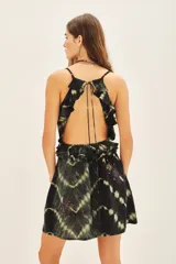 Vestido corto negro con estampado tie-dye en tonos beige, con breteles finos, escote en V con volados y bordado de flores rojas.