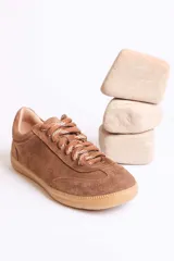 Zapatillas bajas marrones de gamuza con cordones y detalle de aplique de fresa en los cordones.