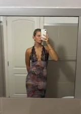 Vestido largo de microtul con estampado floral, escote en V profundo con borde de encaje negro y espalda descubierta con tirantes finos ajustables.