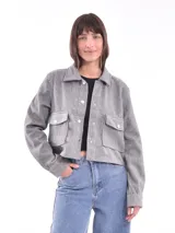Chaqueta corta gris jaspeado con cuello camisero, cierre frontal con botones a presión, bolsillos de parche con solapa en el pecho y mangas largas.