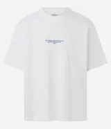 Remera de algodón blanca, corte oversized, con cuello redondo y manga corta. Presenta un pequeño estampado de texto en color azul claro en el pecho.