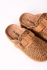 Zuecos color camel con plataforma, detalle de tachas y hebilla dorada.