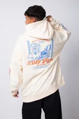 Buzo canguro amarillo ocre oversize de algodón rústico con capucha, cordones negros con letras blancas, bolsillo frontal y puños y cintura acanalados. Presenta estampados en el frente y las mangas.