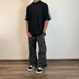 Pantalón jean color beige, de corte holgado y estilo cargo, con múltiples bolsillos laterales.