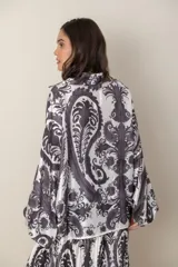 Camisa italiana de satén de seda estampada en blanco y negro, con cuello camisero y mangas murciélago.