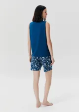 Conjunto de pijama azul con estampado de flores blancas, compuesto por musculosa con bolsillo en el pecho y short con cintura elástica.