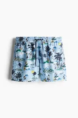 Short de baño celeste con estampado de palmeras, personas y paisajes playeros. Tiene elástico en la cintura y cordón de ajuste.