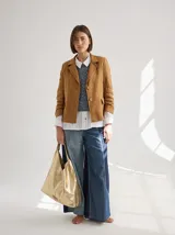 Blazer color mostaza de lino con corte estructurado, solapas con pespuntes y bolsillos con solapa.