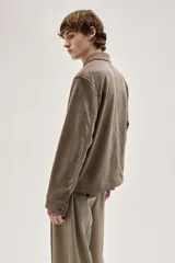 Campera marrón con cuello clásico y cierre frontal. Tiene bolsillos insertados al bies con botón a presión, bolsillo interior y botón en los puños. Corte estándar y forro interior.
