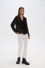 Blusa blanca de viscosa con cuello en V, volados frontales y cierre con botones.