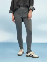 Pantalón jean skinny gris claro, tiro medio, con bolsillos delanteros y traseros.