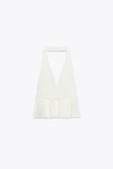Top blanco de cuello halter y escote pico. Bajo acabado en volantes.