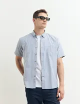 Camisa de manga corta con rayas verticales azules y blancas, cuello abotonado y bolsillo en el pecho.