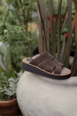 Sandalias marrones de gamuza con plataforma y tiras con aberturas.