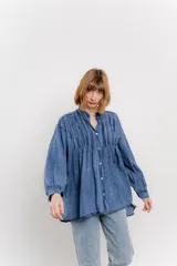 Camisa oversize blanca de algodón con pliegues frontales.