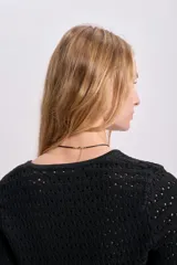 Cardigan corto de punto calado color negro, con escote en V y cierre frontal con lazo.