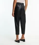 Pantalón zanahoria color marrón claro confeccionado en material sintético con cintura elástica, cordón ajustable con punteras metalizadas, bolsillos laterales y traseros.