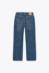 Pantalón de jean color crudo, de tiro alto, corte recto y largo tobillero. Tiene cinco bolsillos, cierre frontal con cremallera y botón metálico.