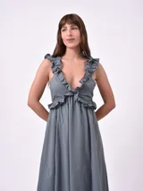 Vestido largo blanco con breteles finos y volados en el escote.