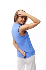Blusa color crema con escote en V, sin mangas y detalle de encaje en hombros y cuello.