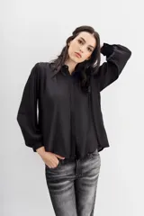 Camisa blanca de manga larga confeccionada en viscosa con acabado sandwash, de textura suave y aterciopelada. Cuello camisero con botón en forma de corazón y frunces en el canesú delantero y la espalda.