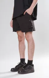 Short de baño negro de calce regular con cuatro bolsillos, elástico en la cintura y cordón para ajustar.