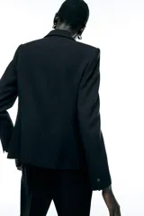 Blazer color beige de corte clásico, con cuello solapa, manga larga, bolsillos frontales con solapa y cierre frontal con un botón.
