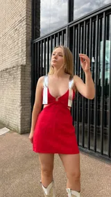 Vestido corto rojo de lino con breteles finos de ecocuero color plateado y detalle cut-out en el centro del pecho.