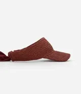 Visera de playa para mujer confeccionada en fibra de papel con textura trenzada. Presenta un diseño de ala ancha y un lazo de tela largo en la parte posterior para anudar.