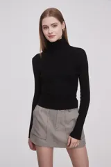 Polera blanca ajustada al cuerpo, de manga larga y cuello alto.
