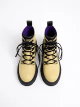 Botín acordonado de cuero color amarillo pastel con pespuntes negros, plataforma track negra y tirador trasero.