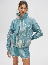 Campera rompevientos estilo biker con capucha desmontable, color celeste con estampado de nubes blancas y detalles en blanco.