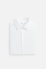 Camisa blanca de corte regular fit, con cuello italiano, manga larga con puños abotonados y cierre frontal con botones.