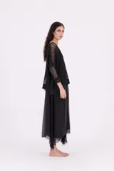 Sweater negro de punto abierto, con escote en V pronunciado y mangas tres cuartos. Presenta un calce amplio y holgado.