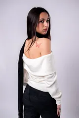 Sweater blanco de punto con hombros descubiertos y cuello amplio.