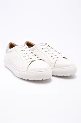 Zapatillas urbanas color blanco, con suela de goma y detalles en gris en el talón.