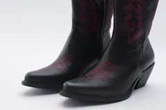 Bota texana de cuero negro con bordados en el lateral y taco bajo.