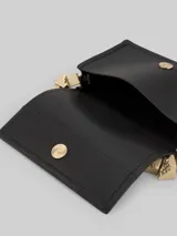 Bolso de mano negro de poliéster con asa rígida dorada con forma de cubos.