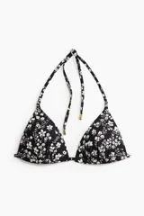 Top de bikini triangular negro con estampado floral blanco, con tirantes finos y copas con push-up.
