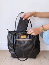 Bolso tote negro de cuero con textura tipo cocodrilo, doble asa larga y forro de tela.