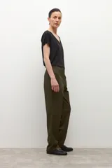 Pantalón de corte recto y tiro medio en color verde oliva, con cierre frontal de cremallera y botón, y bolsillos laterales.