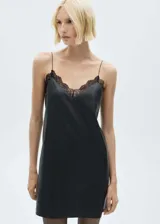 Vestido corto negro de estilo lencero con tirantes finos y escote en V adornado con encaje negro.