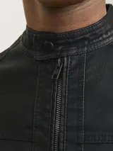 Chaqueta biker negra de cuero sintético con cierre de cremallera, cuello mao con botón a presión, detalles acolchados en los hombros, bolsillos laterales con cremallera, puños con cremallera y forro de poliéster reciclado.