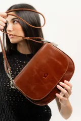 Cartera bandolera marrón de cuero natural con estructura rígida, forro interior de tela, bolsillo interno con cierre y terminaciones impecables.