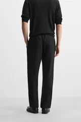 Pantalón negro de corte recto con cintura elástica ajustable con cordón, bolsillos laterales y traseros.