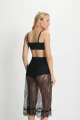 Pollera midi de encaje floral negro, con cintura elástica y ruedo con volados.