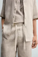 Bermuda negra de lino con calce relajado. Presenta cintura elástica ajustable con cordón, bolsillos frontales y un bolsillo trasero de plastrón.