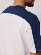 Remera de hombre azul marino con mangas y cuello amarillo, y logo de la marca Rusty estampado en el pecho.